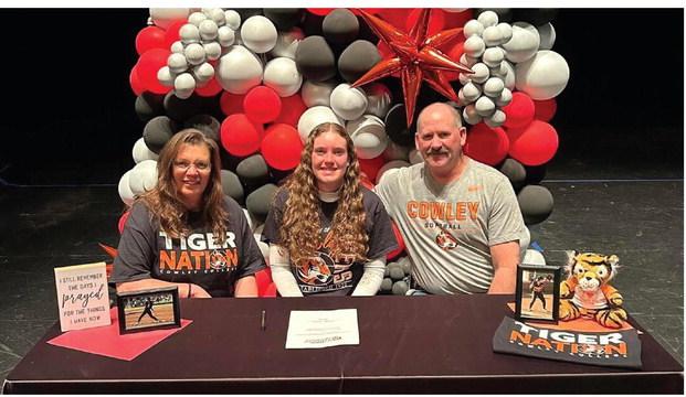◄ Dacey Morris, center, signs with Cowley College to play softball. She is pictured with her parents, Deb, left, and Rick.